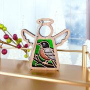 The Forged Flare® American Robin Ornament is a 3.5" stained glass angel figurine from Mother's Angels®, featuring green and white accents—an ideal bird lover gift, perfectly displayed among festive berries and wintry trees in the background.