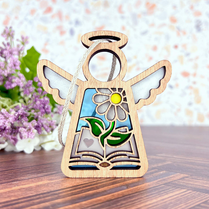 The Book Lovers Ornament by Forged Flare® is a 3.5" Mother's Angels® wooden angel figurine with cut-out wings, daisy and heart details—perfect as a book club or author gift. Stands upright on wood with painted accents.