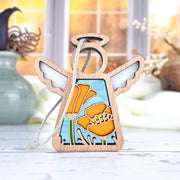 The Forged Flare® California Poppy Ornament is a 3.5" Mother's Angels® figurine with white wings, a halo, and vibrant orange poppy stained-glass details, set against a cozy, sunlit room with vases and soft decor in the background.