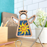 The Celestial Sun Ornament | 3.5" (H) Angel Figurine by Forged Flare® features cutout wings and a yellow sun on blue glitter—perfect as a Christmas ornament or unique beach gift for modern spaces from the Mother's Angels® collection.