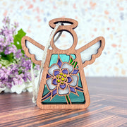 The Forged Flare® Columbine Ornament is a 3.5" Mother's Angels® figurine featuring white wings, a halo, and a stained-glass style Columbine flower design—ideal as a Christmas tree ornament or heartfelt gift.