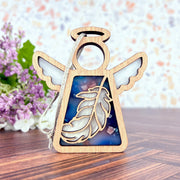 The Feather Ornament | 3.5"(H) Angel Figurine by Forged Flare® features a semi-transparent blue and white feather design with a silver string—ideal as a mindfulness gift or Christmas ornament from the Mother's Angels® collection.