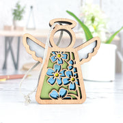 The Forged Flare® Forget-Me-Not Ornament is a 3.5" tall Mother's Angels® wooden angel figurine with cut-out blue flowers, a halo, and wings—perfect as a charming Christmas tree ornament.