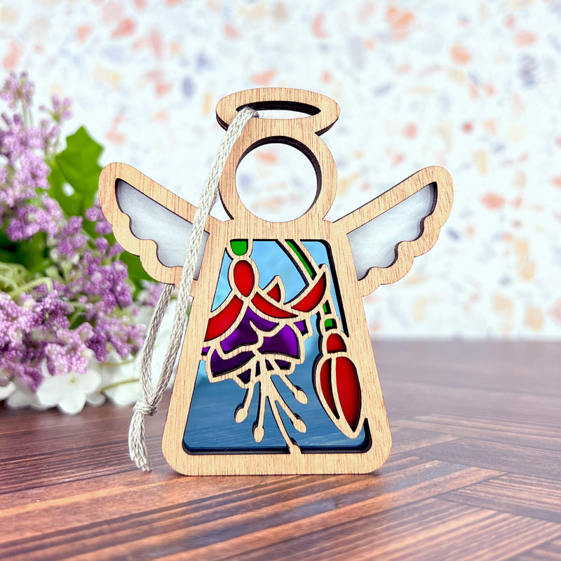 The Forged Flare® Fuchsia Ornament is a 3.5" Mother's Angels® wooden angel figurine with stained glass-style wings and floral accents—ideal as a flower gift or Christmas tree ornament. Purple flowers accent the scene for extra charm.