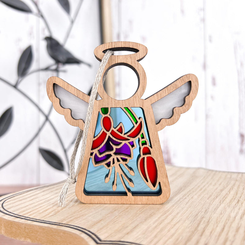 The Fuchsia Ornament by Forged Flare® is a 3.5" Mother's Angels® figurine with stained-glass style red and purple flowers, wings, halo, light wood base, and hanging cord—ideal as a Christmas ornament or unique flower gift.