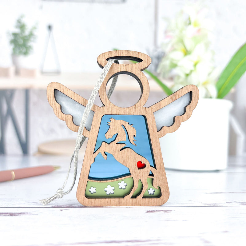 The Forged Flare® Horse Ornament | 3.5" (H) Angel Figurine by Mother's Angels® features a prancing wooden horse with cut-out wings, halo, and a red heart—perfect as a unique horse memorial gift. Hangs from a silver string.