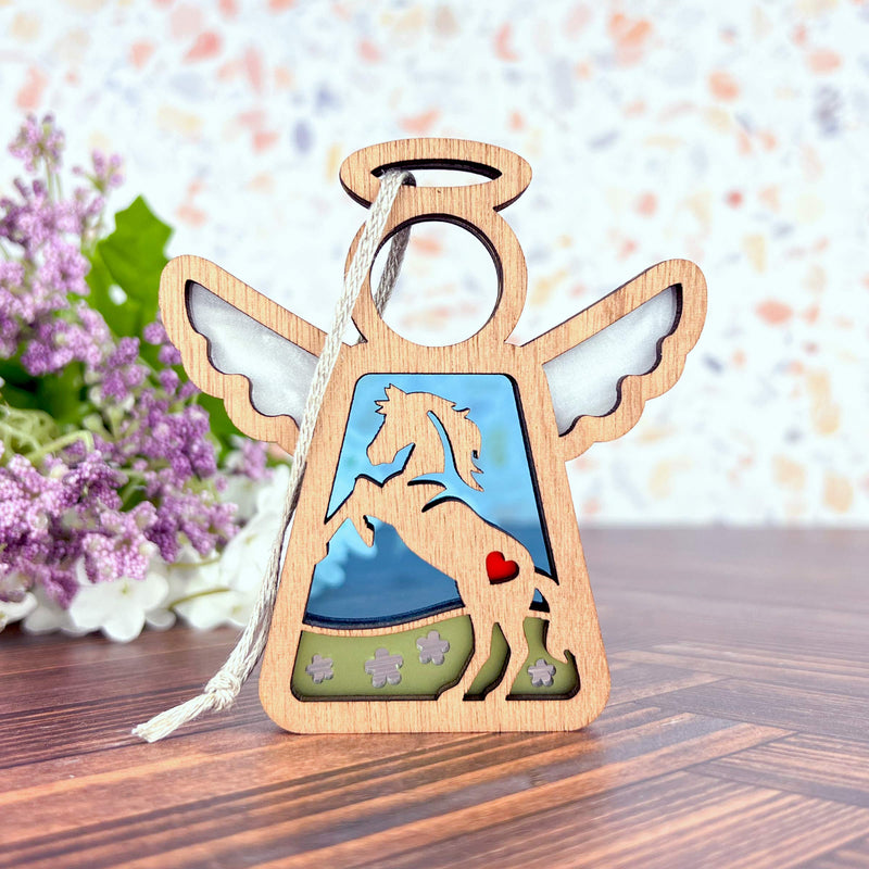The Forged Flare® Horse Ornament | 3.5" (H) Angel Figurine from Mother's Angels® features a horse cutout, red heart, clouds, and blue sky—ideal as horse decor or a memorial gift. Includes white hanging string; shown near purple flowers.