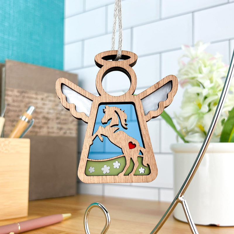 The Forged Flare® Mother's Angels® Horse Ornament is a 3.5" wooden angel figurine with cutout wings, a rearing horse, red heart, and green grass—ideal for horse décor or as a thoughtful memorial gift.