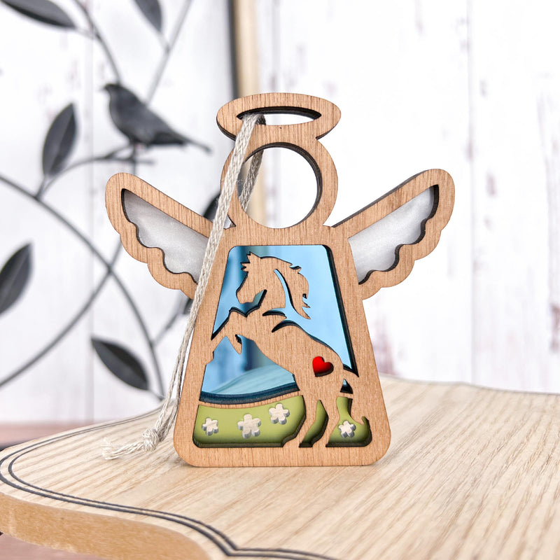 The Forged Flare® Mother's Angels® Horse Ornament is a 3.5" wooden angel figurine featuring a rearing horse cut-out, silver wings, red heart, white flowers, and blue sky—an ideal horse memorial gift. Includes bird decoration in back.