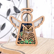 The Forged Flare® Owl Ornament is a 3.5" Mother's Angels® angel figurine with a cut-out owl and green grass. It comes with a hanging string and rests on wood, making it a perfect gift for bird lovers or bird watchers.
