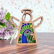 The Peacock Ornament by Forged Flare® is a 3.5" Mother's Angels® angel figurine featuring stained-glass style wings and a vibrant peacock design—an ideal gift for bird lovers.