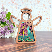 The Purple Orchid Ornament, a 3.5" angel figurine by Forged Flare® from the Mother's Angels® line, features cut-out wings, a halo, and stained glass-style purple and yellow flowers—perfect for collections or as a unique Christmas tree ornament.