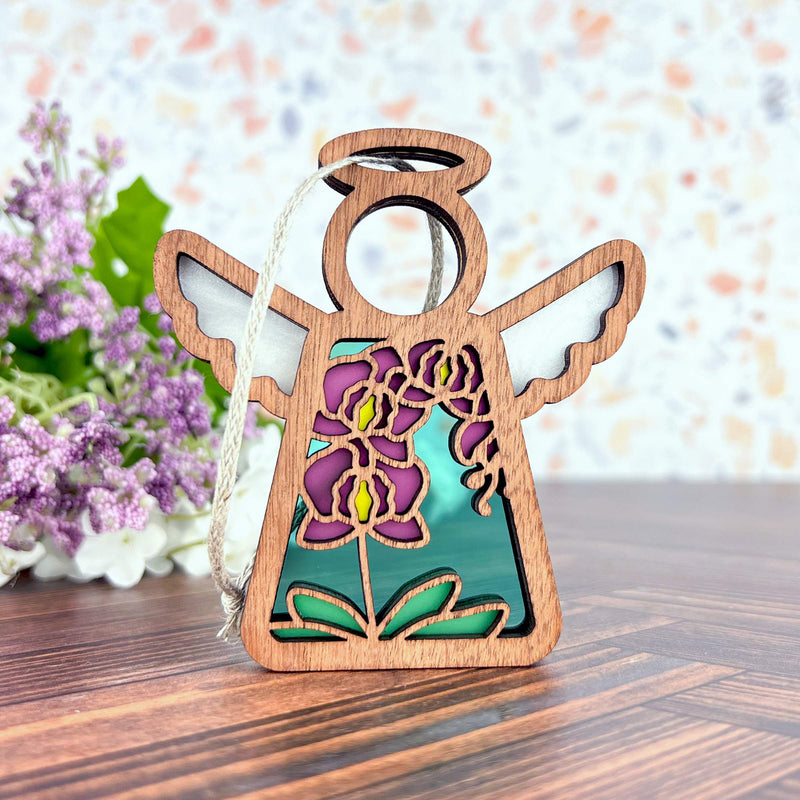 The Purple Orchid Ornament, a 3.5" angel figurine by Forged Flare® from the Mother's Angels® line, features cut-out wings, a halo, and stained glass-style purple and yellow flowers—perfect for collections or as a unique Christmas tree ornament.