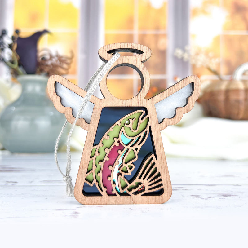 The Rainbow Trout Fish Ornament by Forged Flare® is a 3.5" wooden Mother's Angels® figurine with white wings and a trout cutout, complete with hanging string for use as a Christmas tree ornament.
