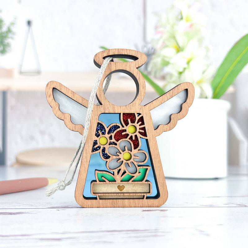 The Forged Flare® Red, White & Bloom Ornament is a 3.5" Mother's Angels® figurine with white wings, a halo, and glittery flowers—ideal as a Christmas tree ornament or decor accent.