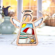 The Forged Flare® Summer Beach Ornament is a 3.5"H wooden angel figurine by Mother's Angels®, featuring a sun, umbrella, waves, and starfish—ideal for Christmas trees or beach house decor. Displayed on a white surface with vases and autumn trees blurred behind.