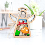 The Forged Flare® Toadstool Mushroom Ornament is a 3.5" Mother's Angels® figurine with white wings, halo, and stained glass red-orange mushroom on a green-blue background. Includes white string for hanging as a charming Christmas ornament.
