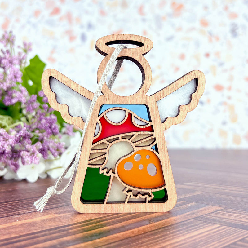 The Forged Flare® Toadstool Mushroom Ornament is a 3.5" wooden Mother's Angels® figurine with stained glass-style inlays, featuring a red and orange mushroom design—perfect as a unique Christmas tree ornament.
