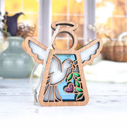 The Forged Flare® White Dove Ornament (3.5" Mother's Angels®), featuring a wooden bird with cutout wings, olive branch, and pink glitter heart, hangs by a white string—ideal as a memorial or bird lover gift. Blurred vases and autumn scenery in background.