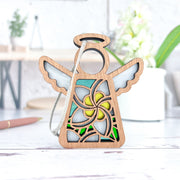 The Forged Flare® White Plumeria Ornament is a 3.5" Mother's Angels® angel figurine with cutout wings, a halo, and stained glass-style plumeria in yellow, green, and white—perfect as a unique plumeria gift.