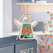 The Forged Flare® Sugar Maple Leaf for Charity Ornament is a 3.5" Mother's Angels® figurine with white wings and a maple leaf design, perfect for indoor display. Inspired by the Appalachian Mountains.