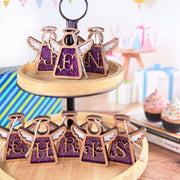 Handcrafted purple letter ornament with 'JEN' and 'CHRIS' monogram ornaments, featuring glittery initial designs, displayed on a wooden stand as personalized Christmas ornaments.