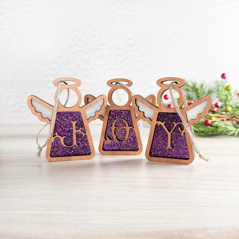Handcrafted purple letter ornament set spelling 'JOY' with glittery initial designs, crafted as personalized Christmas ornaments for a festive holiday display.