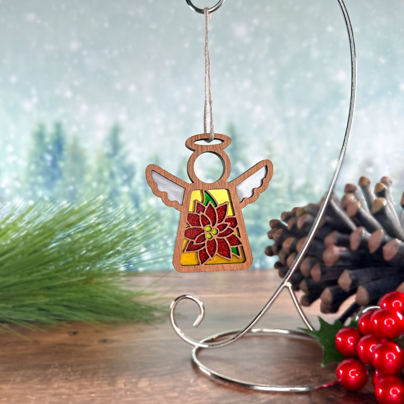 The PREORDERS CLOSED! Poinsettia Ornament, a 3.5" handmade angel figurine by Mother's Angels® from Forged Flare®, features a festive red and green poinsettia design—perfect as a unique Christmas tree decoration or holiday gift.