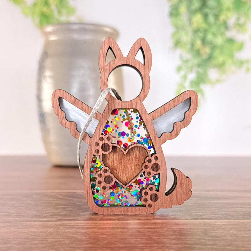 The Forged Flare® Forever By My Side Dog Angel Ornament is a wooden dog-shaped ornament with angel wings, a glitter-filled heart cutout, and a silver loop—ideal as a personalized gift for dog lovers.