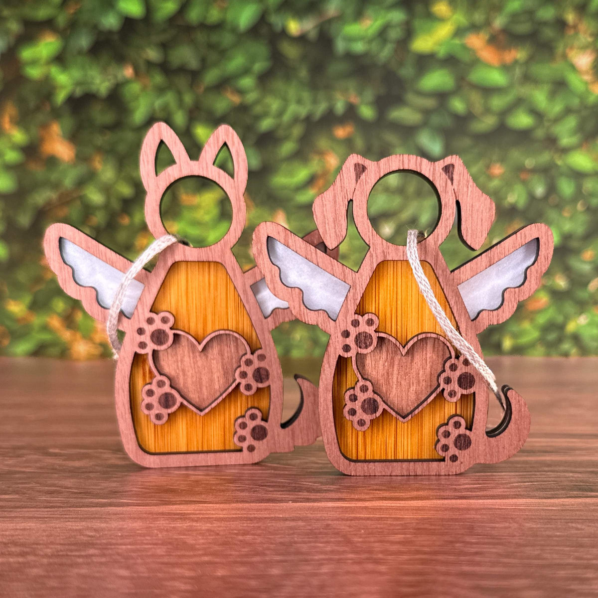 Wooden dog figurines with heart designs on a wooden surface and green foliage background