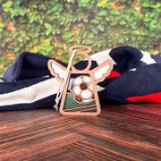 This soccer ball ornament, a 3.5" Mother's Angels® angel figurine, stands on wood before red, white, and blue folded fabric—perfect as a soccer mom gift set against leafy greenery.