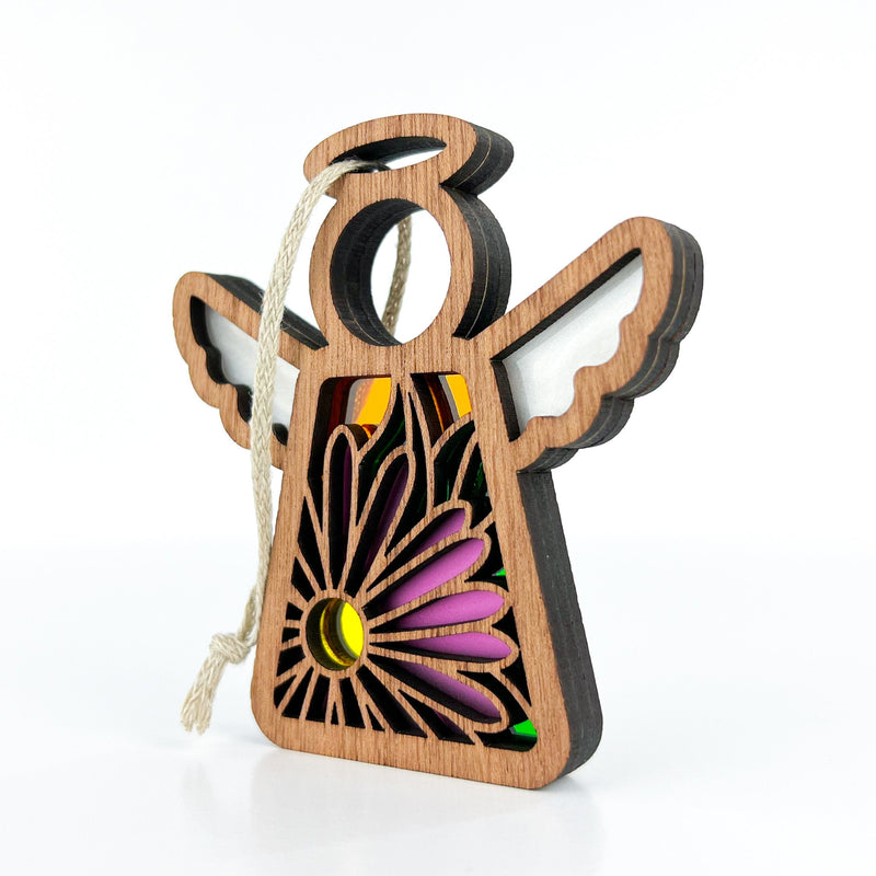 The Forged Flare® Aster Ornament | 3.5" (H) Angel Figurine from Mother's Angels® features a cutout purple aster flower, colorful stained glass, white wings, and a twine loop for hanging; shown on a white background.