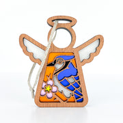 The Forged Flare® Blue Jay Ornament is a 3.5" wooden Mother's Angels® figurine with white wings, a blue jay and pink flower design, a white background, and an attached string loop—perfect for bird lovers or as a unique gift.