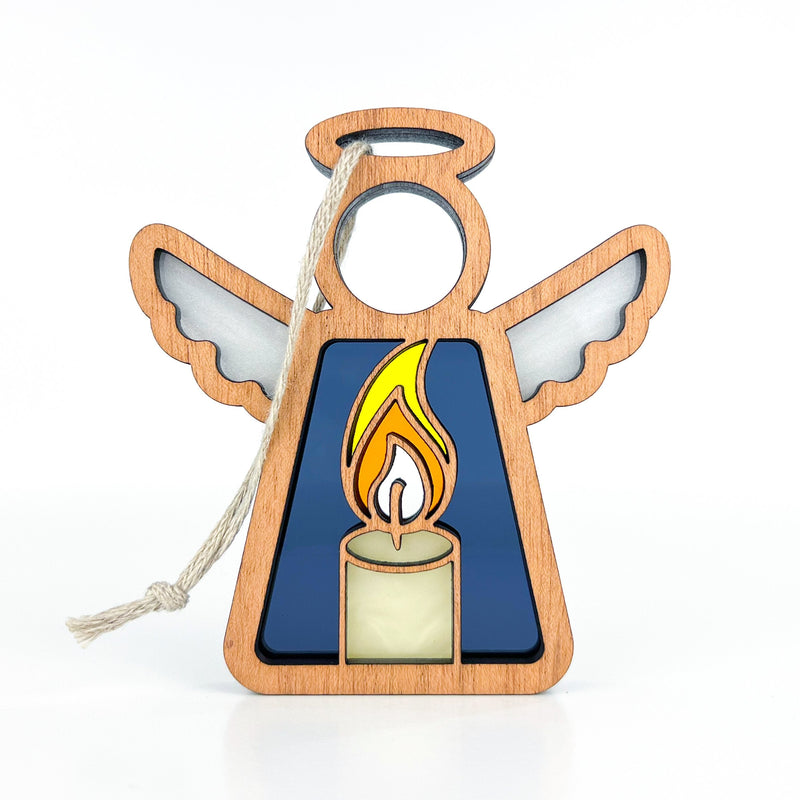 The Burning Candle Ornament by Forged Flare® is a 3.5" wooden Mother's Angels® figurine with white wings, blue body, and a yellow candle design. Includes white hanging string. Perfect as a Christmas or angel ornament. Photographed on a plain white background.