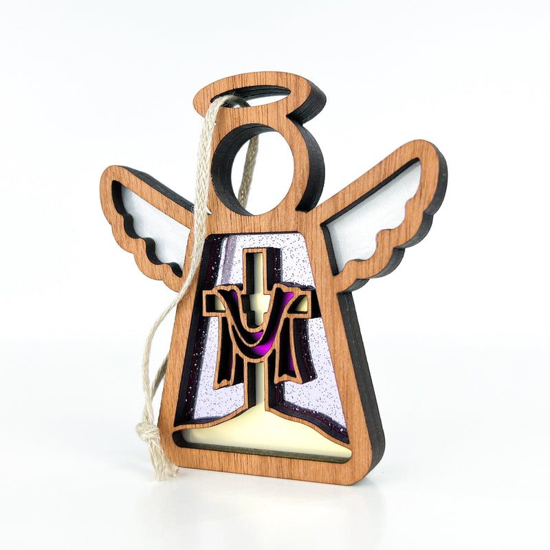 The Limited Edition By Grace Ornament from Forged Flare® is a 3.5" Mother's Angels® figurine featuring a wooden angel with white wings, halo, and purple/gold cross draped in purple cloth, plus a looped string for easy hanging.
