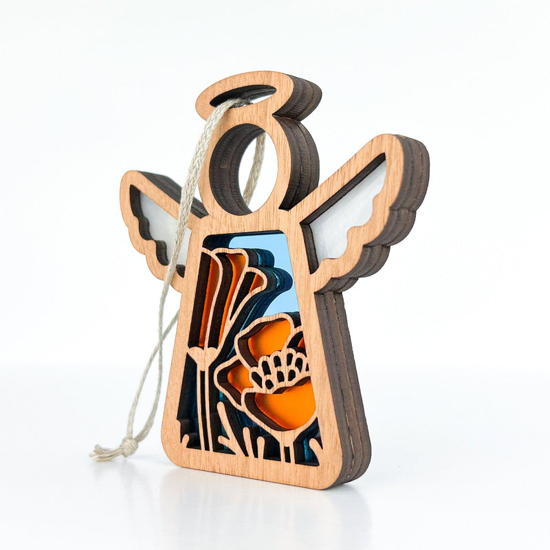 The California Poppy Ornament by Forged Flare® is a 3.5" Mother's Angels® angel figurine with layered cutout orange and blue flowers, string loop for hanging, shown on a white background.
