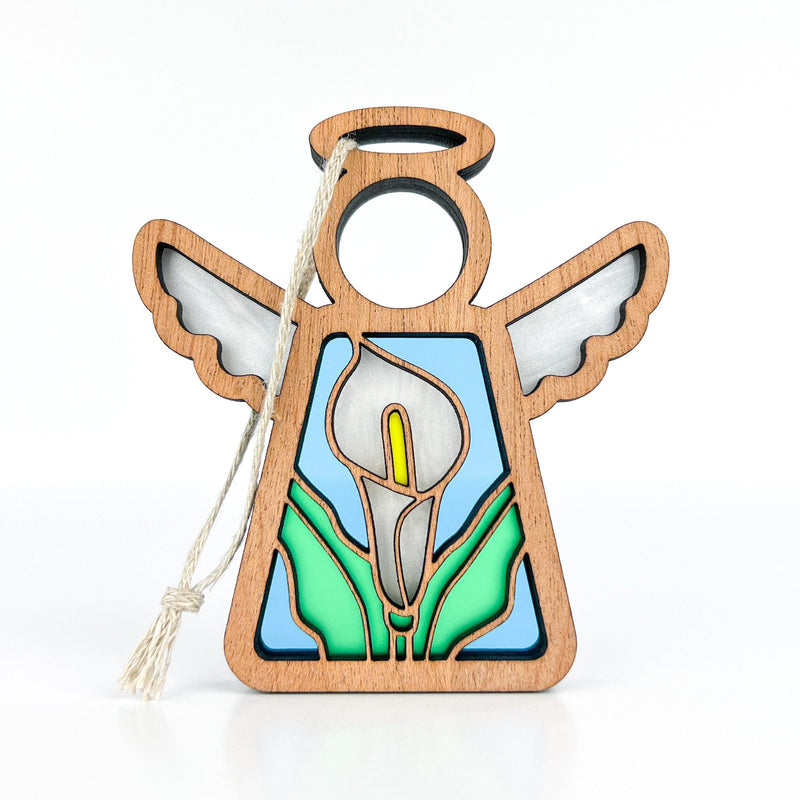 The Forged Flare® Mother's Angels® Calla Lily Ornament is a 3.5" wooden angel figurine with a cutout halo, white wings, stained-glass-style calla lily, green leaves, yellow center, and comes with a string for hanging.