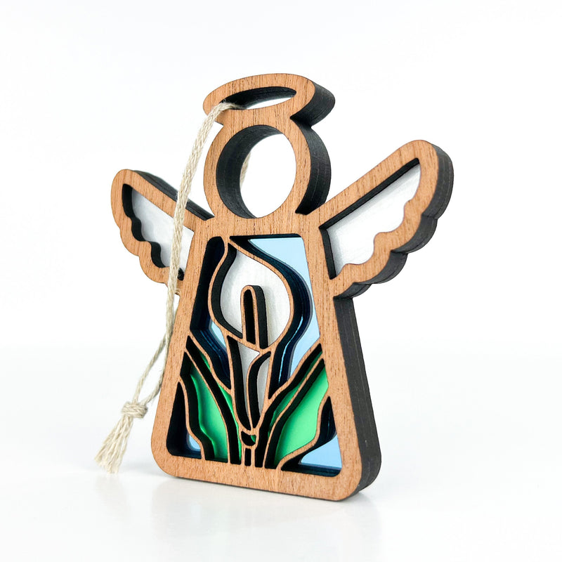 The Forged Flare® Calla Lily Ornament is a 3.5" Mother's Angels® figurine with white wings, a halo, and stained-glass-style calla lily design, perfect as a charming hanging decoration for your Christmas tree.