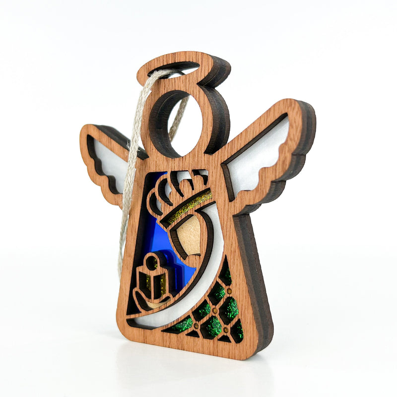 The Christmas Nativity Green Wise Man 3.5" Angel Figurine by Forged Flare® features cutout wings, a crown, heart, and gifts in blue, green, and gold accents with a hanging string. Part of Mother's Angels®, it's perfect for angel fans. Plain white background.