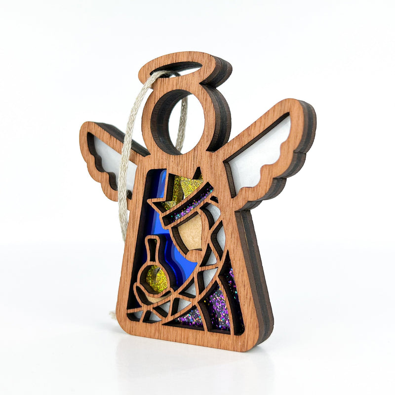 The Forged Flare® Christmas Nativity Purple Wise Man 3.5" Angel Figurine features cut-out details, stained glass-style design, and glitter accents—an ideal Nativity gift or addition to your Mother's Angels® ornament collection.