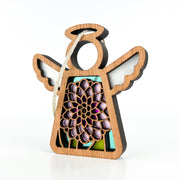 The Forged Flare® Chrysanthemum Ornament with Imperfections is a 3.5" handcrafted wooden angel figurine from the Mother’s Angels® series, featuring white wings, a circular halo, and a colorful chrysanthemum centerpiece. String included for hanging.