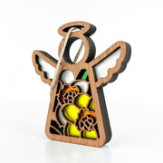 The Forged Flare® Mother's Angels® 3.5" Daffodil Ornament is a wooden angel figurine with white wings, a halo, yellow and orange daffodil details, and a string loop for hanging, shown on a white background.