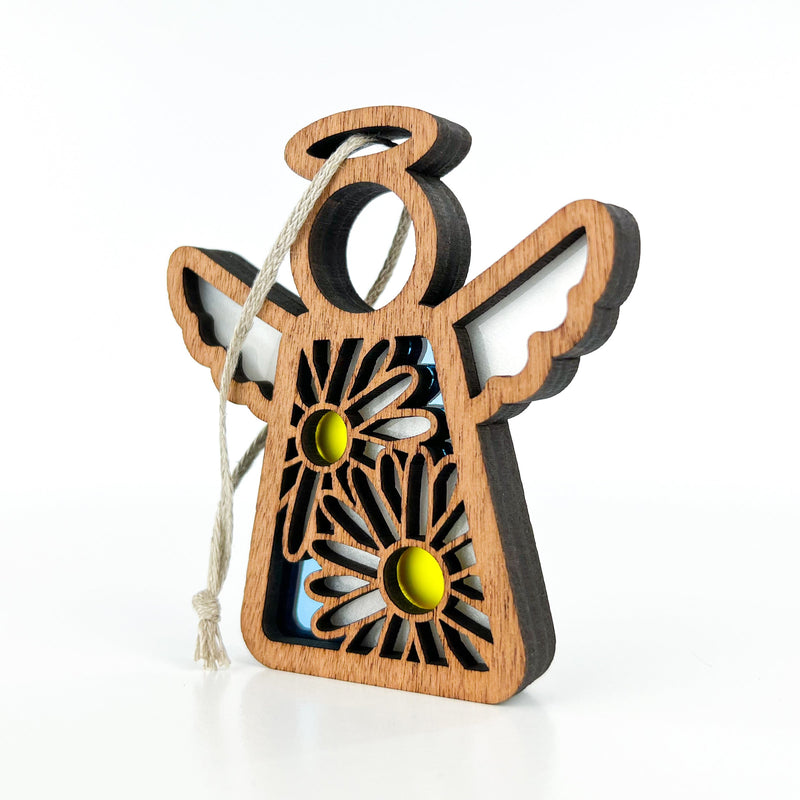 The Forged Flare® Mother's Angels® Warehouse Return - Daisy Ornament is a 3.5" wooden angel figurine with white wings, floral cut-outs, and a hanging string, perfect for collectors or Amazon warehouse return resellers.