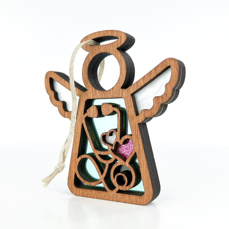 The Forged Flare® Mother's Angels® 3.5" Doctor/Nurse Ornament has white wings, a stethoscope design, and a pink glitter heart. This collectible angel figurine features a hanging string—perfect as a medical-themed gift or centerpiece.