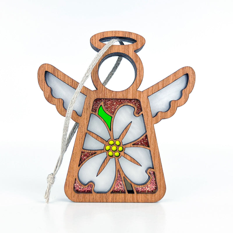 The Forged Flare® Mother's Angels® Dogwood Ornament is a 3.5" wooden angel figurine with white wings, a halo, hanging string, and a dogwood flower with yellow and green accents against pink glitter—ideal for your Christmas tree.