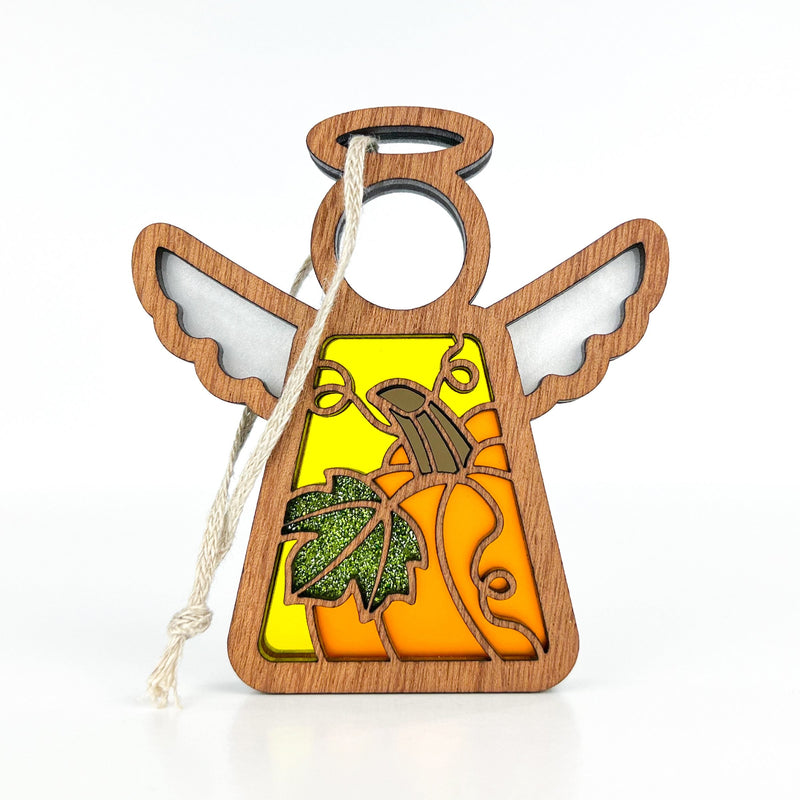 The Festive Pumpkin Ornament by Forged Flare® is a 3.5" (H) Mother's Angels® figurine with white wings, a yellow-orange stained-glass body, green glittery leaf, acorn, and horn—perfect Thanksgiving decor that hangs easily by its string.