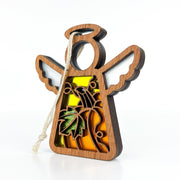 The Festive Pumpkin Ornament by Forged Flare® features a 3.5" angel figurine from the Mother's Angels® collection, with white wings and a yellow body adorned with intricate cut-out designs, including a palm tree. A string loop at the top makes it perfect for hanging as a Christmas tree ornament. Photographed in a plain white studio setting, it is an elegant addition to holiday décor.