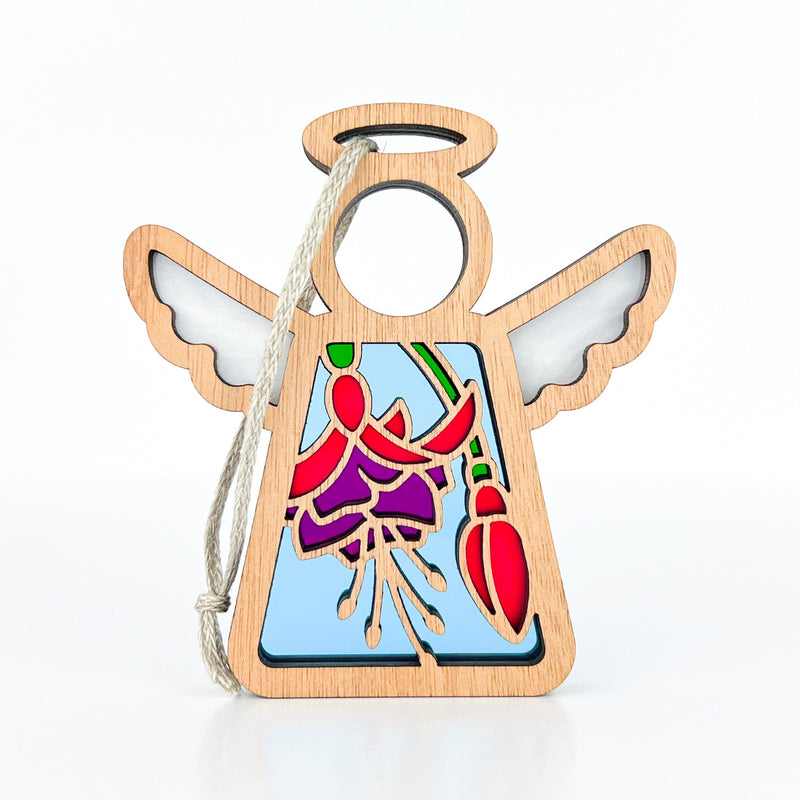 The Forged Flare® Fuchsia Ornament is a 3.5" tall Mother's Angels® wooden figurine with cut-out wings, halo, stained glass-style fuchsia flower panel, and twine loop for hanging. Perfect as a Christmas or floral gift; plain white background.