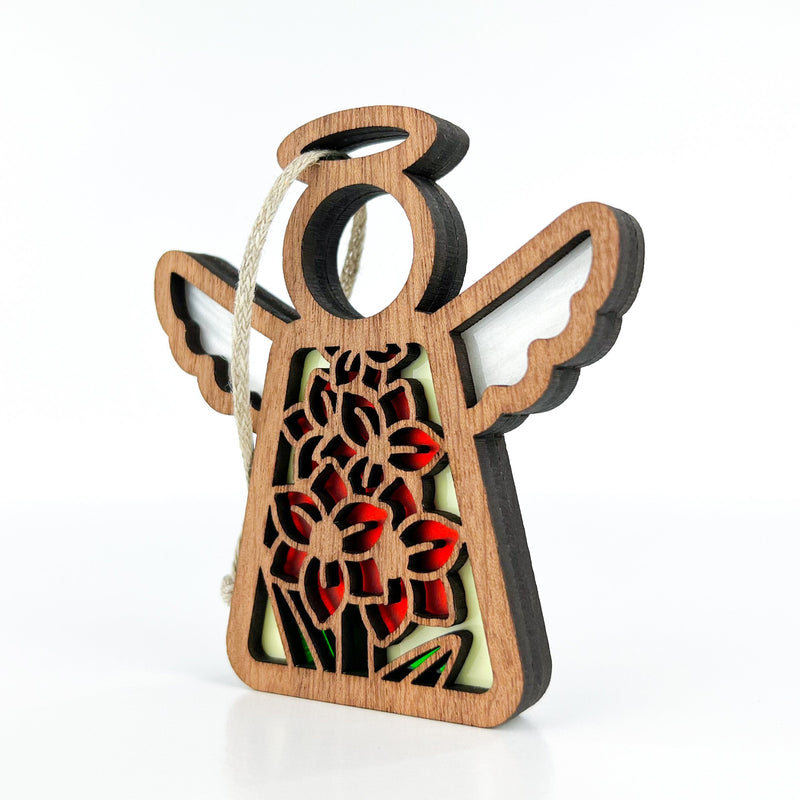 The Forged Flare® Gladiolus Ornament is a 3.5" Mother's Angels® wooden angel figurine with white wings, halo, and a red, green & yellow gladiolus cut-out design, plus a white string loop for hanging. Shown on a white background.
