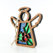 The Forged Flare® Holly Ornament is a 3.5" Mother's Angels® figurine with white wings, a hanging loop, and a stained glass-inspired holly flower design for December, detailed in blue glitter and green.
